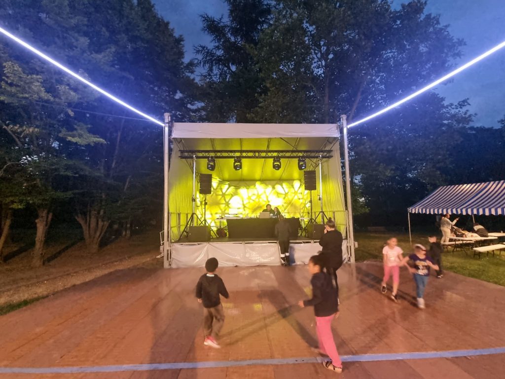 Scène lumineuse animée avec des enfants dansant lors d'un événement à Bougival, organisé par Symbiose Organisation.