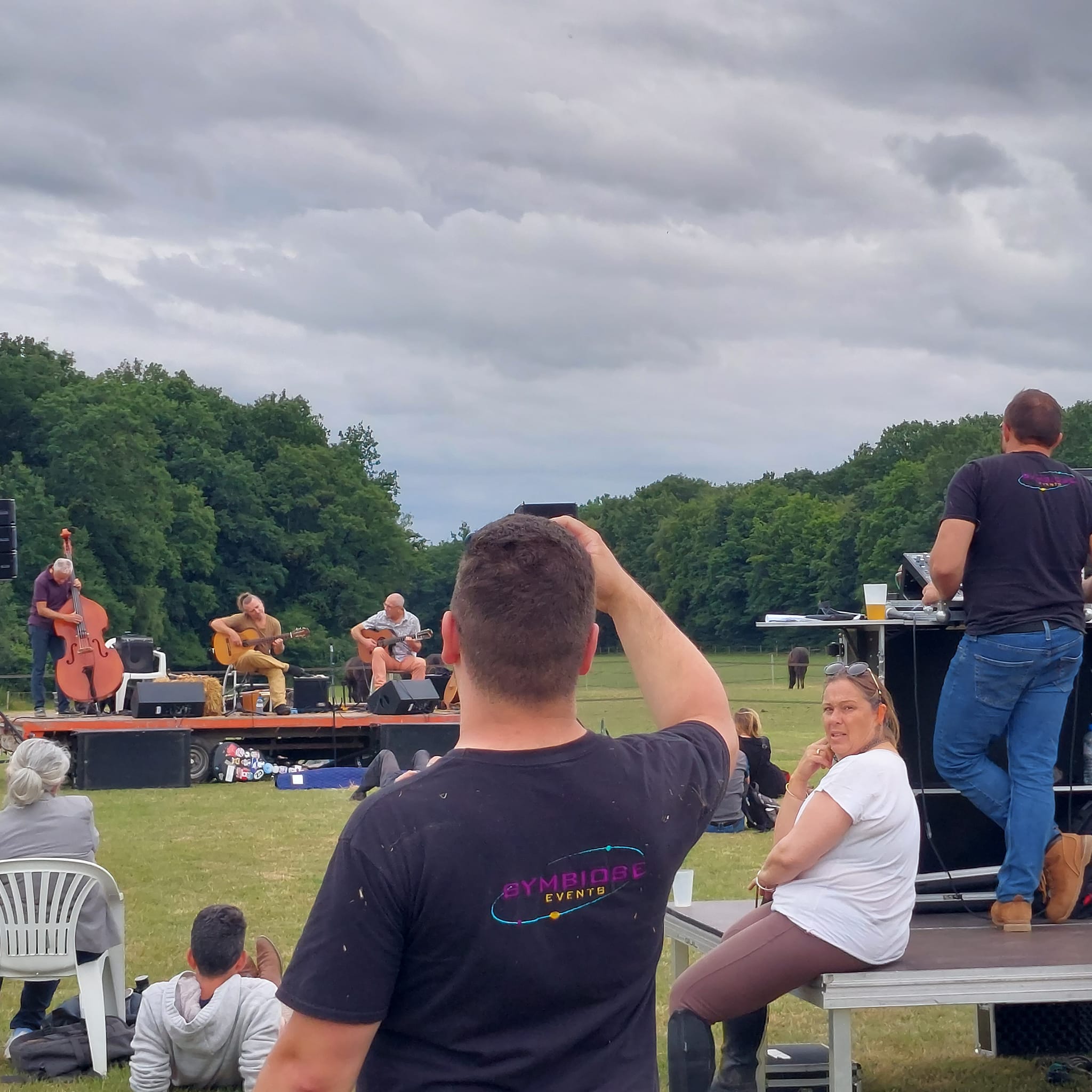 Concert de jazz en plein air, ambiance détendue, avec des musiciens sur scène et des spectateurs profitant du moment.