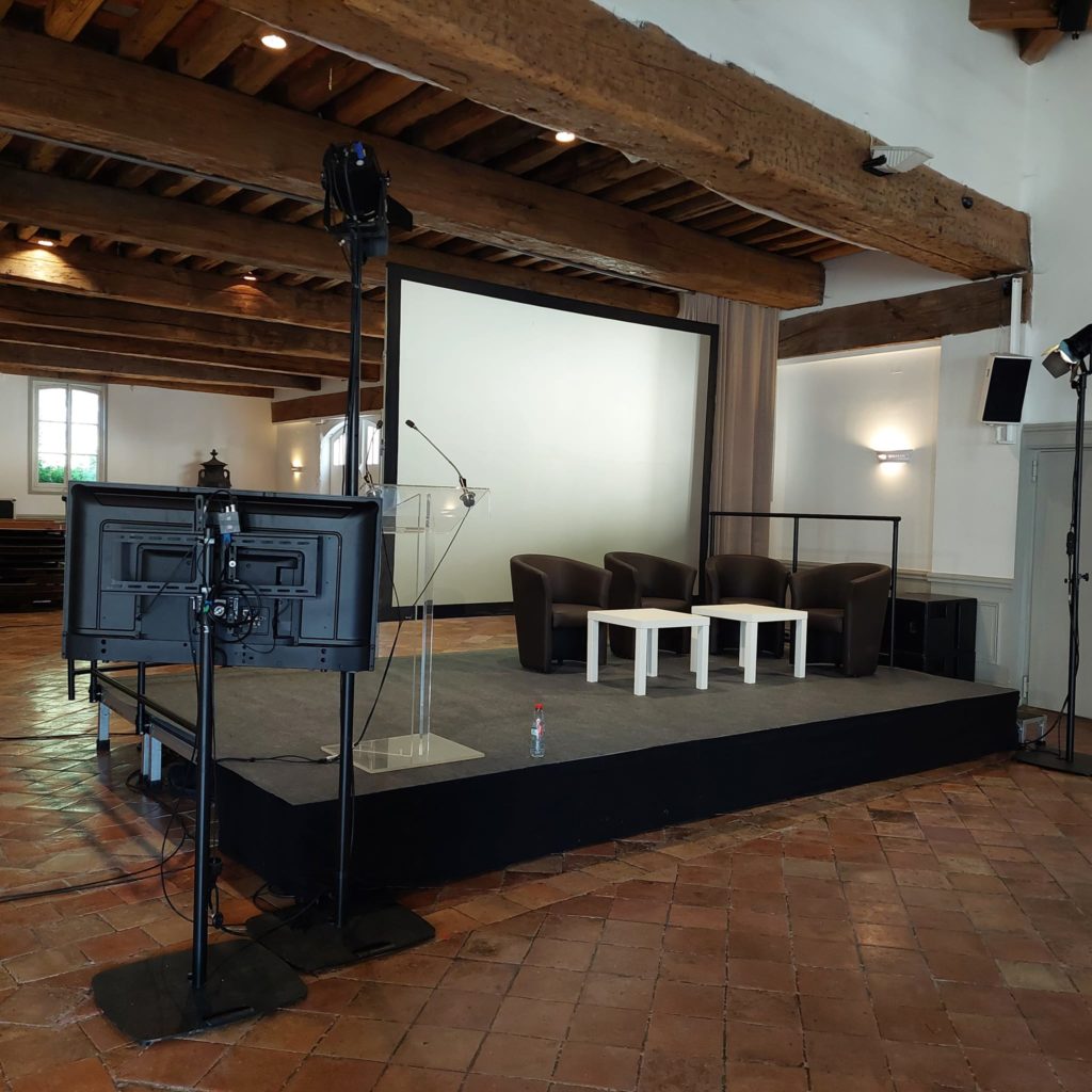 Installation d'une plénière avec écran, chaises, et matériel de sono pour un événement Medef à Grand-Maison.