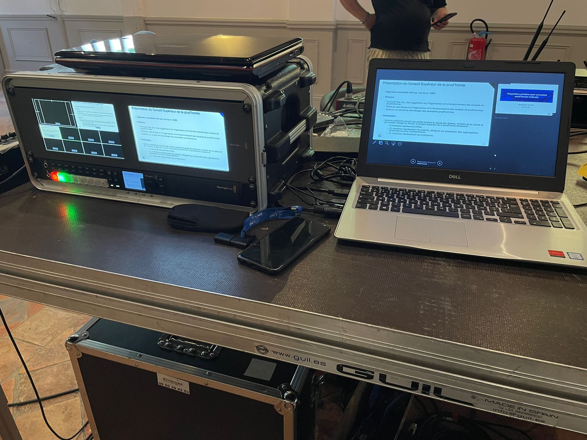 Installation technique avec matériel de sonorisation et un ordinateur portable dans un cadre professionnel.