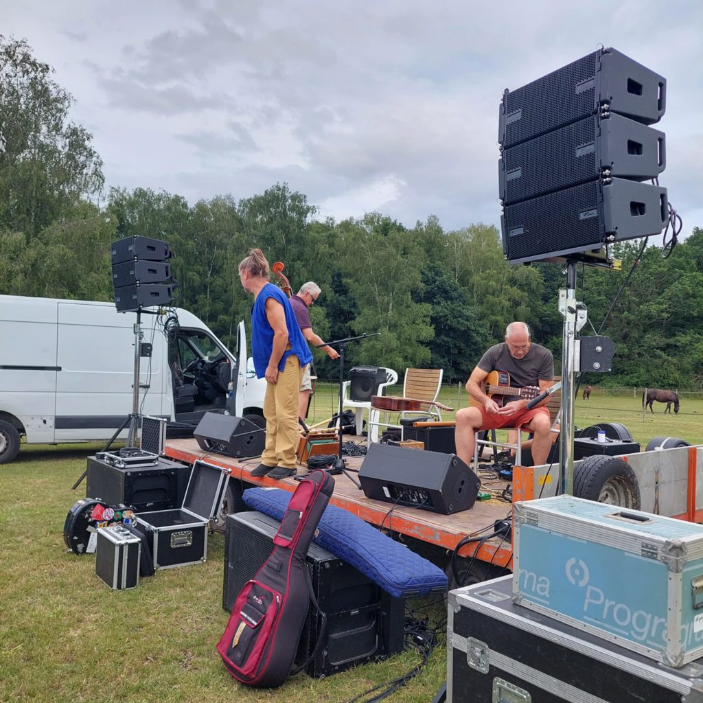 Préparatifs d'un concert champêtre au Haras de la Cense, avec installations sonores et musiciens en action.