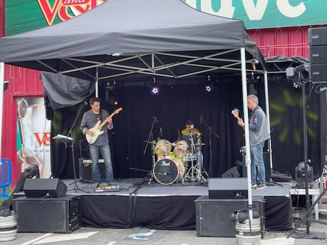 Concert en plein air au V and B de Coignières, avec des musiciens sur scène sous une tente noire. 25 juin 2022.