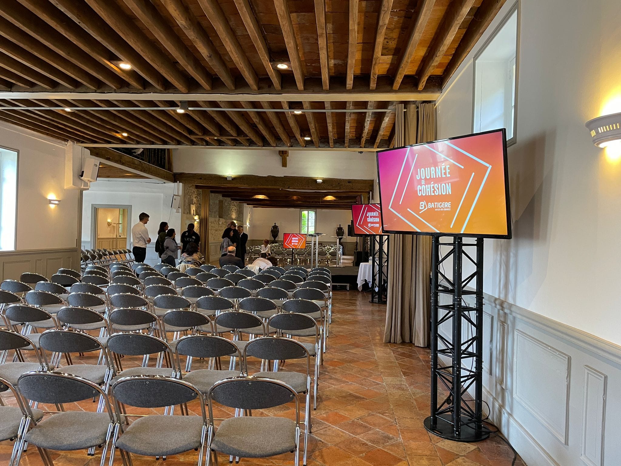 Plénière au domaine de grande maison le 8 septembre 2022, avec sièges et écrans affichant "Journée de Cohésion".