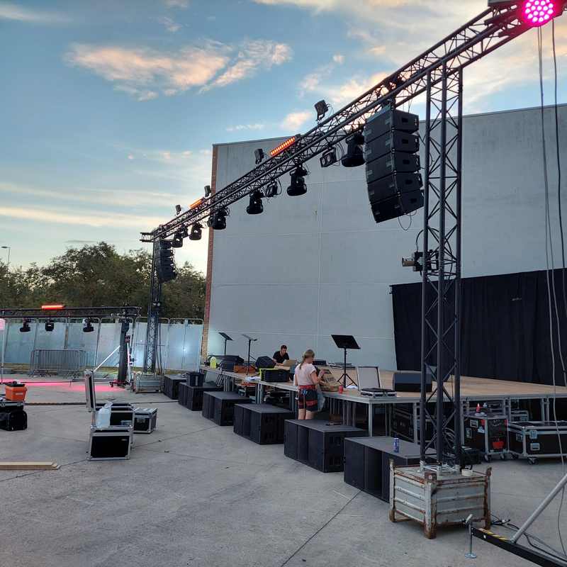 Scène de concert avec équipements sonores et éclairage, préparée pour le Bal des Pompiers de Poissy, 13 juillet 2022.