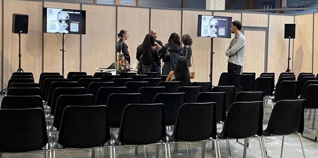 Groupe Studyrama au salon d’expo à Paris, montrant des présentations sur écran, avec des participants en discussion.