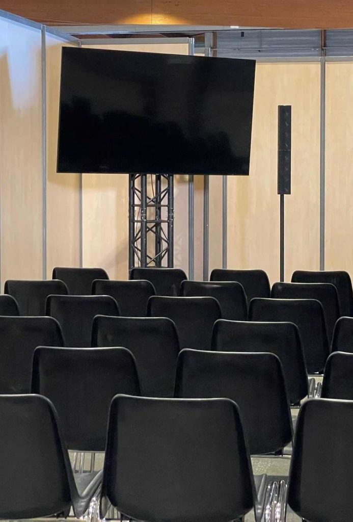 Écran et matériel audio dans un espace d'exposition avec des chaises noires, lors de l'événement Studyrama à Paris.