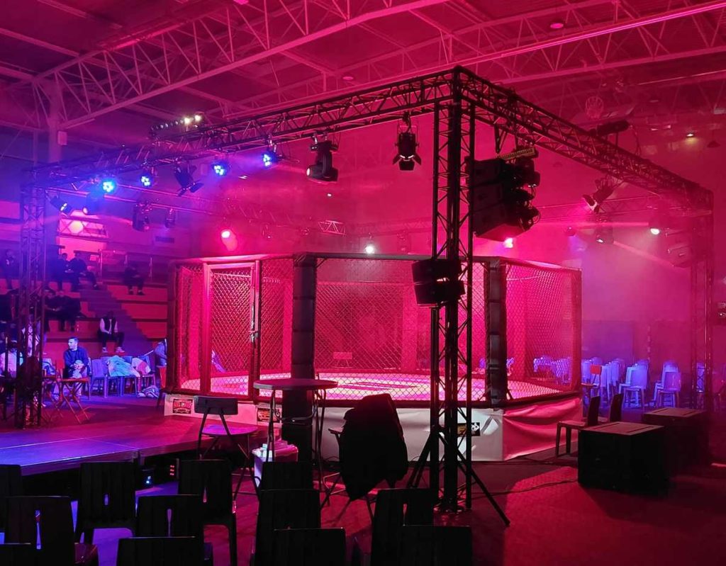 Équipement de son et éclairage pour une compétition de MMA à Coignières, ambiance dynamique avec lumière rose et bleue.