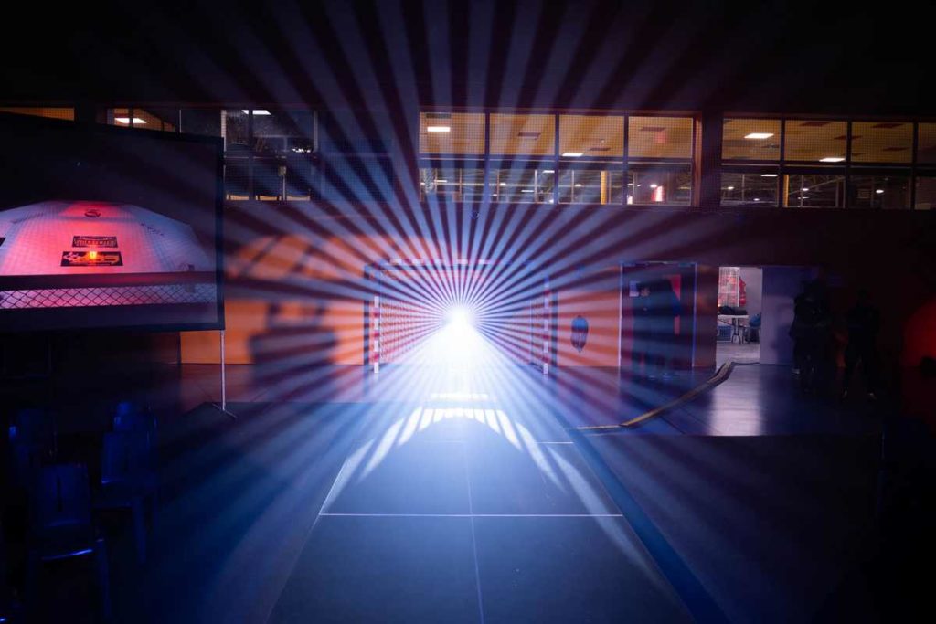Rayons de lumière projetés lors de la compétition de MMA à Coignières, le 26 novembre 2022, mettant en valeur l'événement.