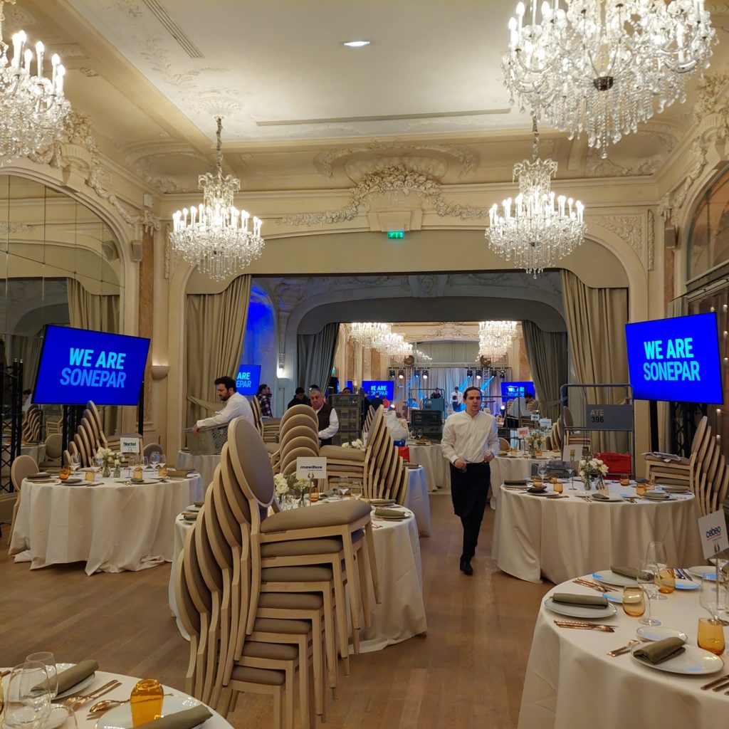 Préparatifs pour un événement au Pavillon Dauphine, avec tables dressées et personnel en attente.