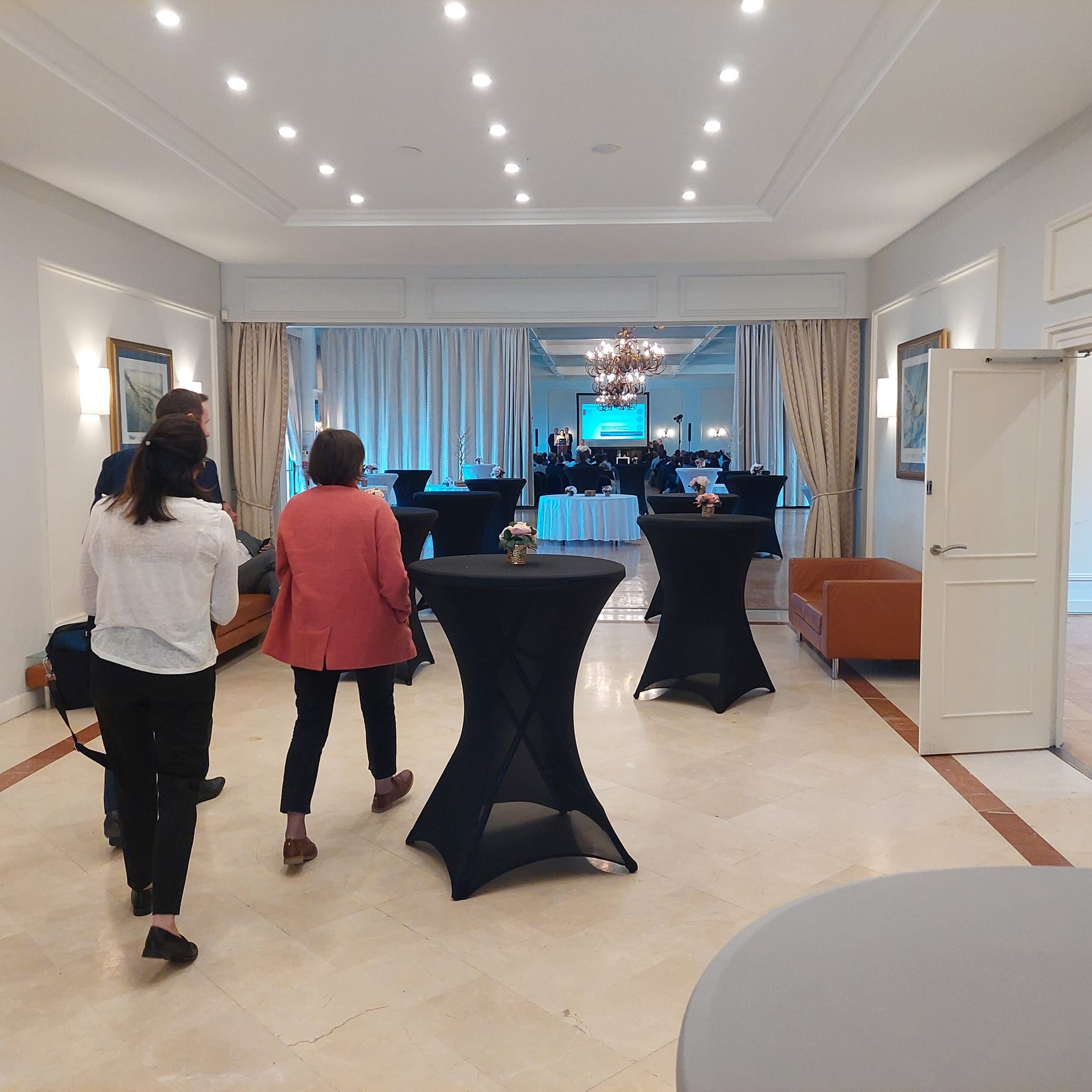 Vue de la Salle Saint Exupéry à Coignières, avec des participants et des tables noires, pour un événement organisé par Symbiose.