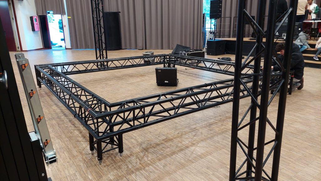 Installation de matériel de sonorisation et d'éclairage pour une soirée gospel, avec structure de régie et micros.