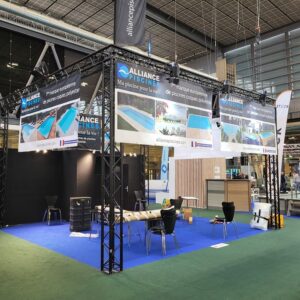 Stand d'Alliance Piscines au salon de Porte de Versailles, mettant en avant leurs produits avec une structure et un éclairage soigné.