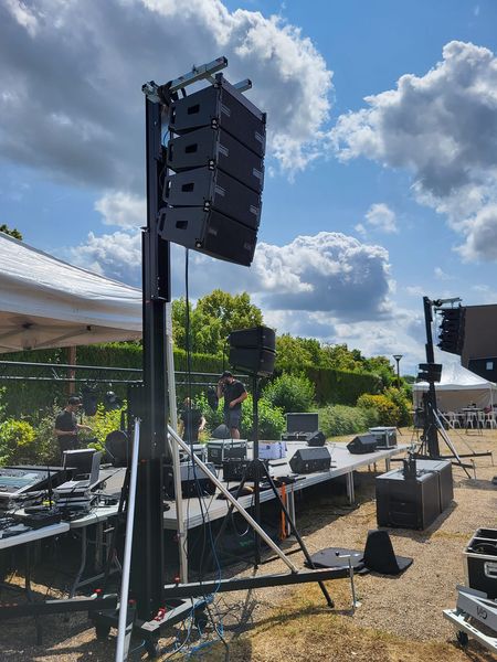 Installation de matériel de sono pour la fête de musique à Coignières, le 21 juin 2023, sous un ciel ensoleillé.