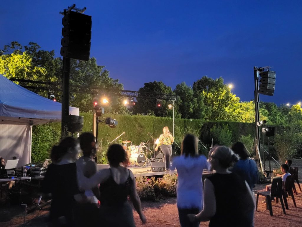 Concert en plein air à Coignières le 21 juin 2023, avec une scène, des musiciens et des spectateurs dansants.