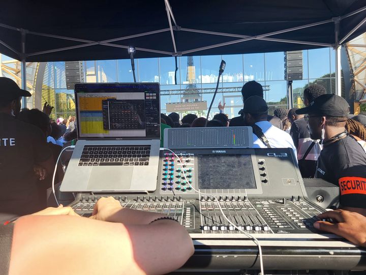 Cabine de son lors de la Marche pour Jésus, avec des équipements audio et une foule en arrière-plan.