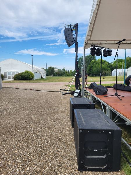 Installation de matériel de sonorisation sur scène pour un événement extérieur à Mantes-la-Jolie, juillet 2023.