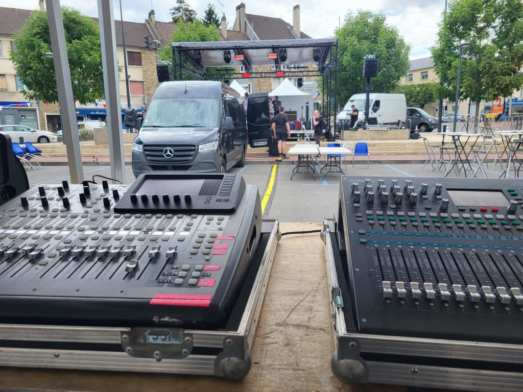 Console de mixage en premier plan, scène montée en arrière-plan pour un événement à St Cyr l’École, le 13 juillet 2023.