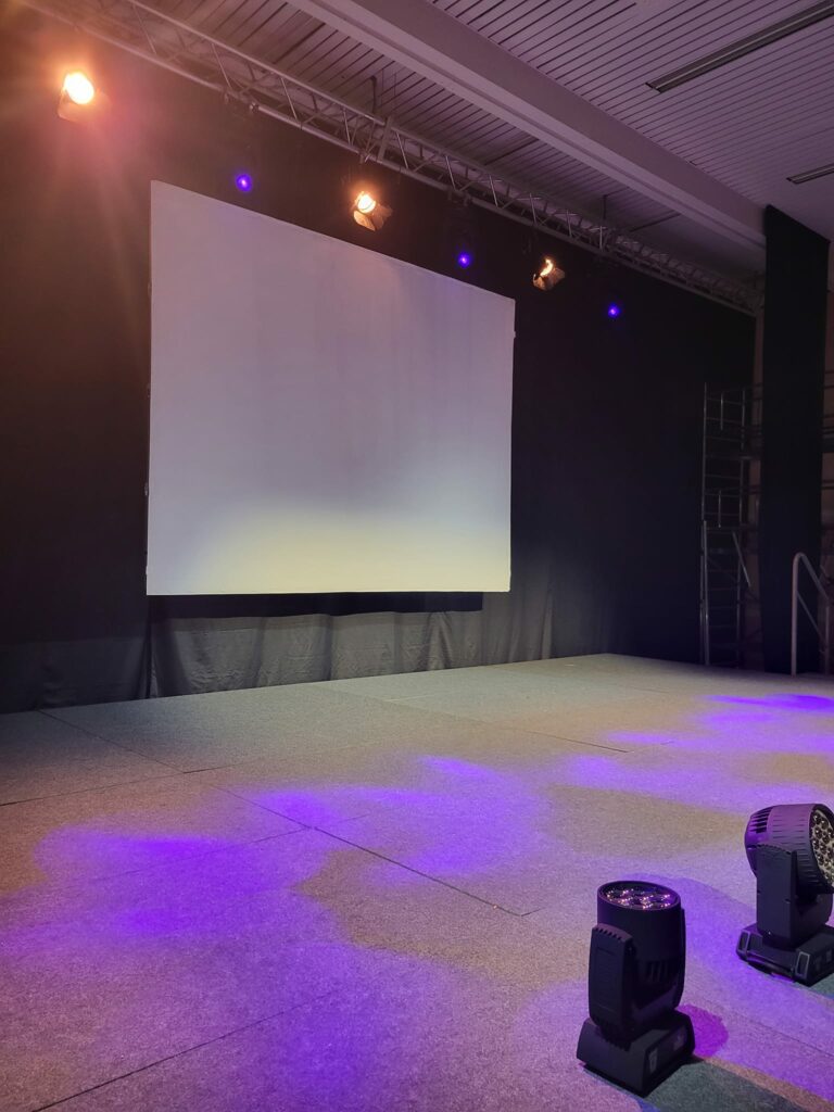 Scène du Théâtre Michel Audiard à Chevreuse avec éclairage professionnel et écran blanc pour un événement dirigé par Paul Dureau.