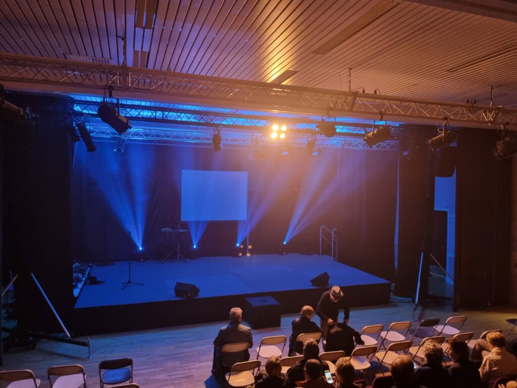 Scène illuminée du Théâtre Michel Audiard avant un événement, avec équipements son et lumière préparés.