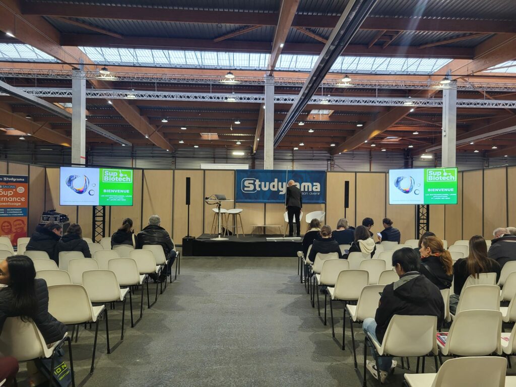 Événement Studyrama à Paris Center, avec une scène préparée et un public en attente. Symbiose Organisation présente son matériel sonore.