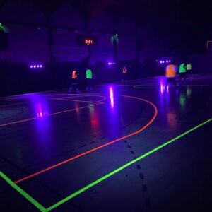 Match de basketball en lumière UV, ambiance colorée et dynamique, le 2 février 2024. Événement par Symbiose Organisation.
