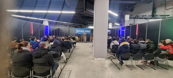 Salle de conférence au Salon Studyrama, avec un public attentif et un intervenant en scène.