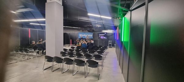Vue intérieure du Salon Studyrama à Espace Champerret, avec des sièges et un écran de présentation.