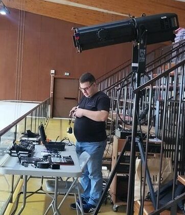 Technicien préparant l'éclairage pour l'événement de gymnastique à Beynes, 29 juin 2024.