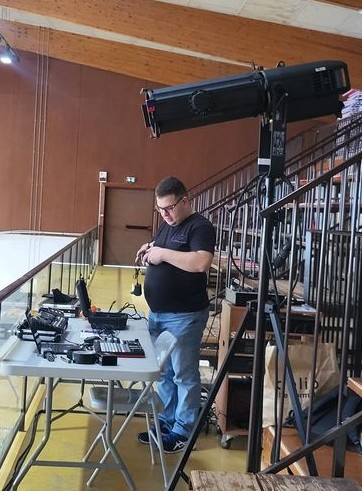 Technicien préparant l'éclairage pour l'événement de gymnastique à Beynes, 29 juin 2024.