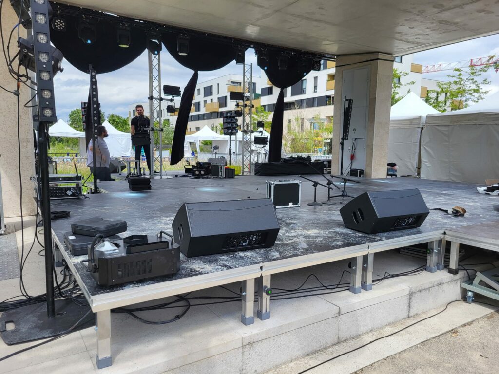 Scène préparée pour l'événement du 14 juin 2024 à Saint Cyr l'École, avec matériel de sonorisation et éclairage.