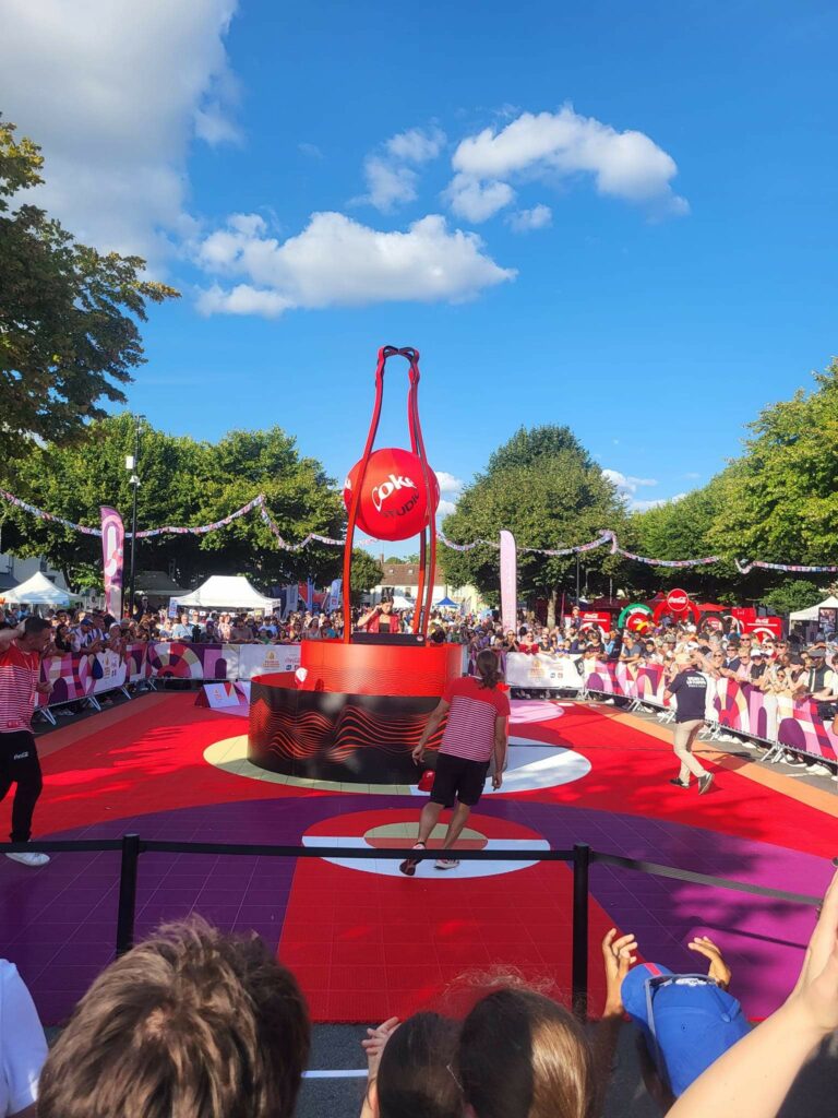 Installation de la sonorisation pour la flamme Paralympique de Chambly, avec scène animée et public présent.
