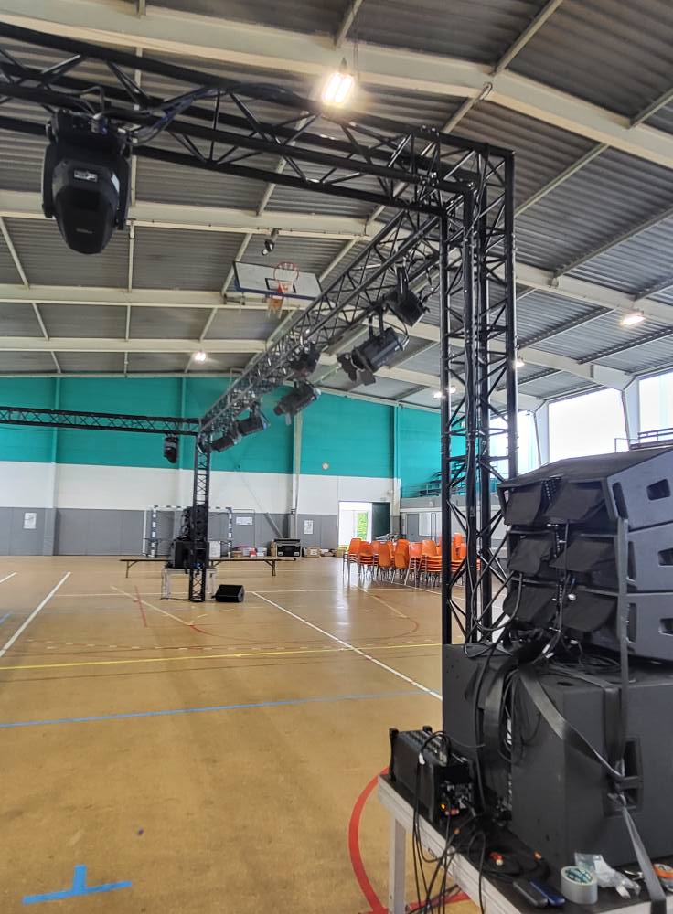 Installation de matériel de sonorisation et d'éclairage dans une salle polyvalente.