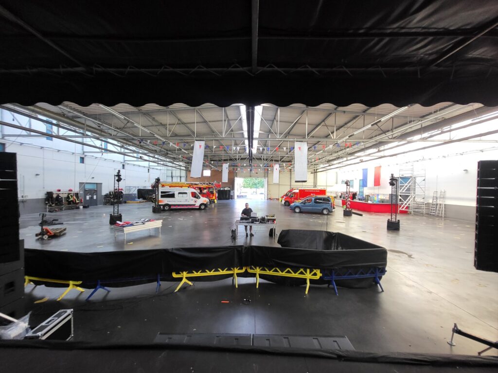 Vue d'un espace événementiel avec matériel de sonorisation et éclairage en préparation pour un événement.
