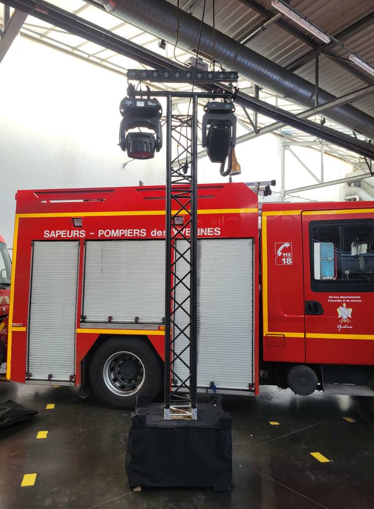 Structure de sonorisation avec éclairage, devant un véhicule de pompiers, utilisée par Symbiose Organisation.