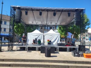 Installation d'une scène avec éclairage et sono, montage en plein air par l'équipe de Symbiose Organisation.