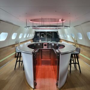 Intérieur d'un espace moderne avec comptoir circulaire, éclairage d'ambiance rose et sièges, conçu pour des événements.