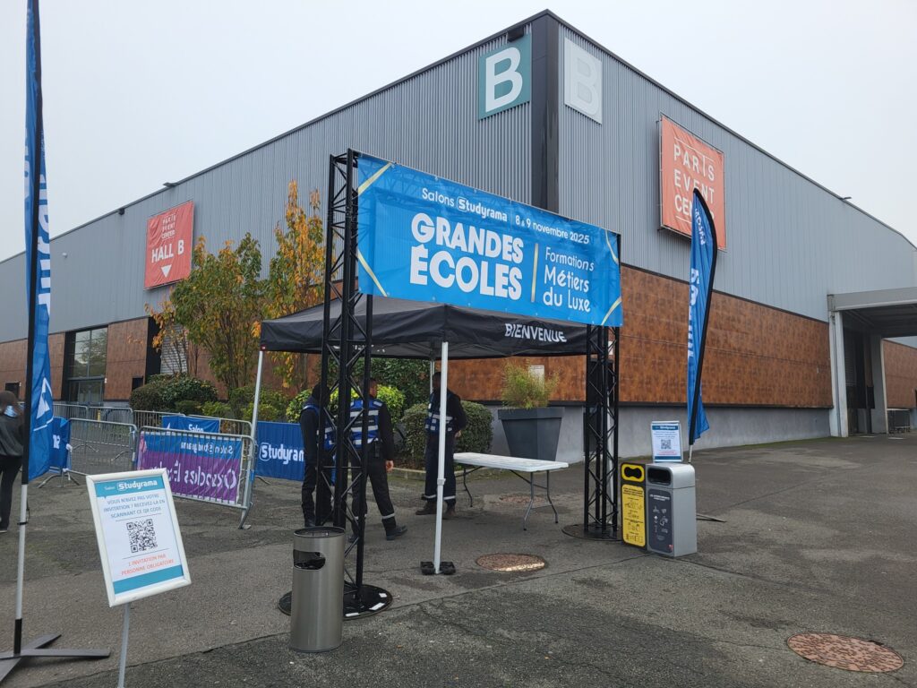 Stand d'accueil pour le salon "Grandes Écoles" au Paris Event Center, avec des banderoles et des agents de sécurité.