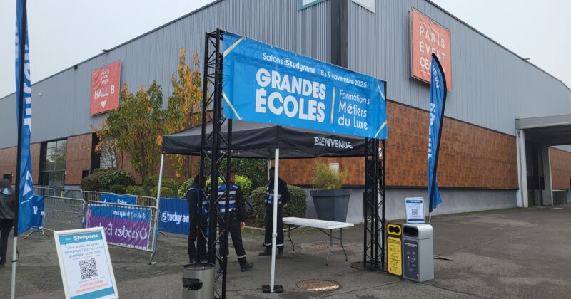 Stand d'accueil pour le salon "Grandes Écoles" au Paris Event Center, avec des banderoles et des agents de sécurité.