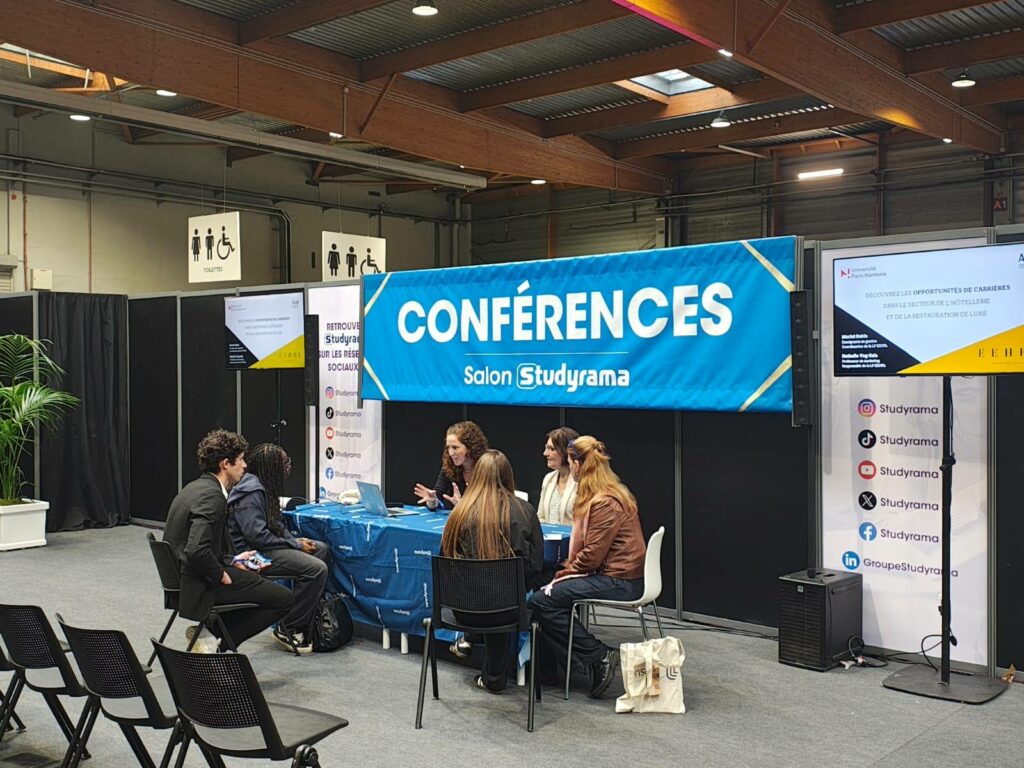 Stand de conférences au Salon Studyrama, avec des intervenants discutant des opportunités de carrière dans l'hôtellerie.