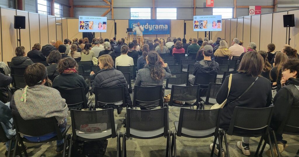 Public assistant à une présentation sur le luxe, mode et design, avec des intervenants et des projections en arrière-plan.