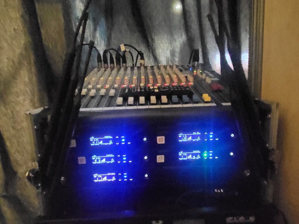 Table de mixage professionnelle avec équipements audio amplifiés, prête pour des installations de sonorisation.