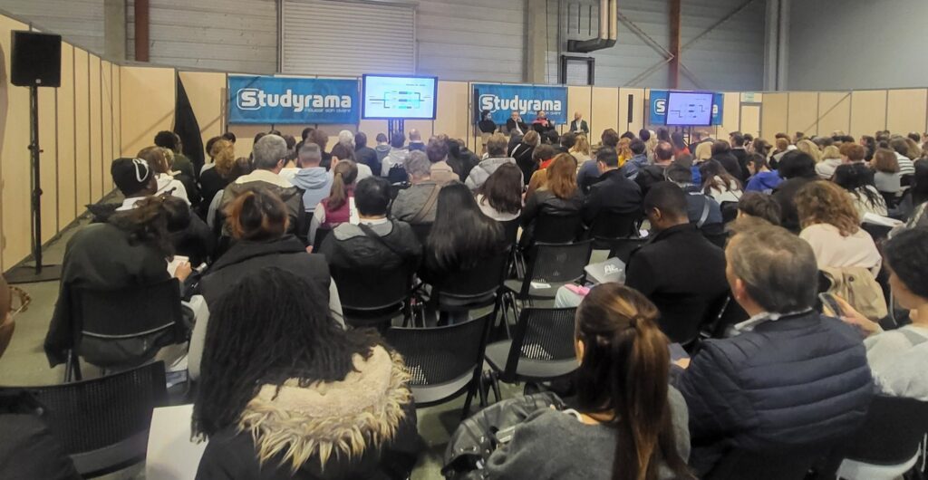 Public nombreux, en salle, lors d'un événement organisé par Studyrama, avec des intervenants sur une scène.