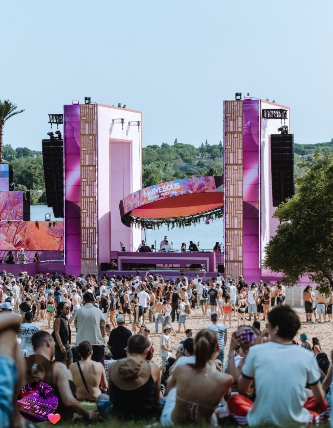 Scène colorée du festival Marvellous Island, avec une foule rassemblée sur la plage, entourée de matériel sonore et d'éclairage.