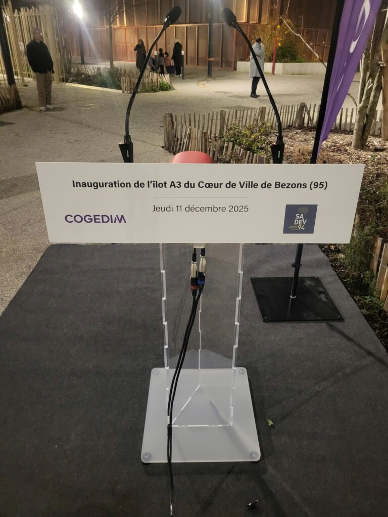Podium d'inauguration pour l'îlot A3 à Bezons, avec câbles audio visibles, le 11 décembre 2025.