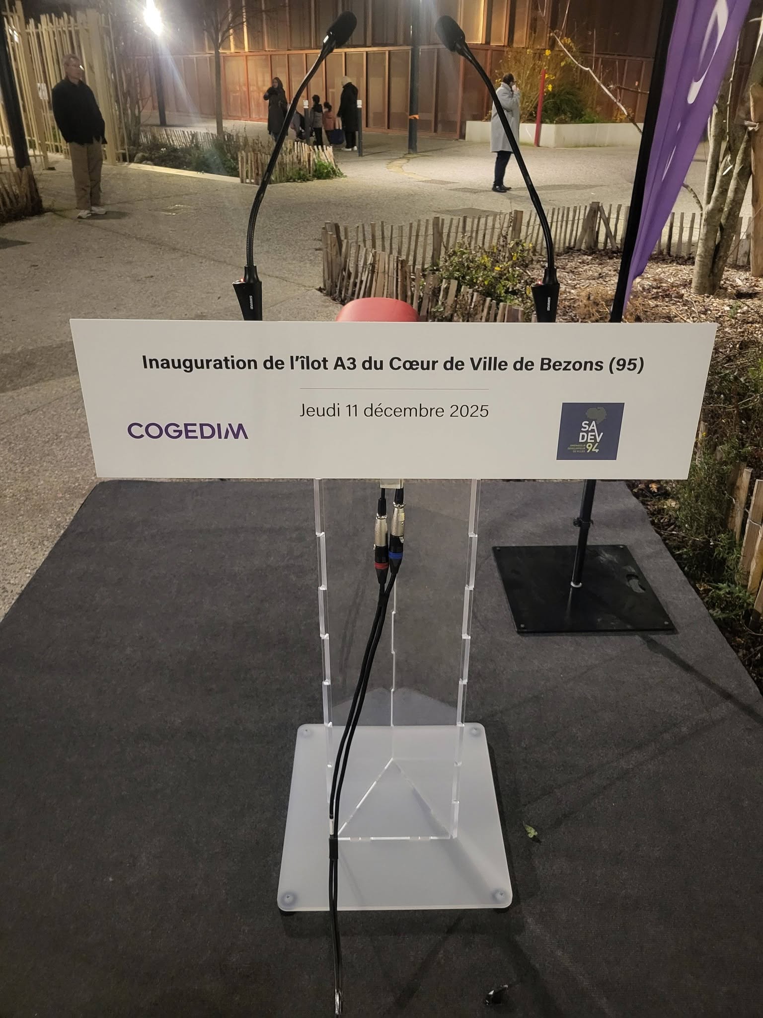 Podium d'inauguration pour l'îlot A3 à Bezons, avec câbles audio visibles, le 11 décembre 2025.