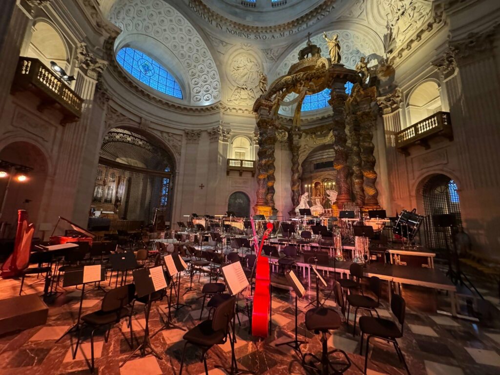 Scène d'une église avec des chaises de concert et des instruments de musique, préparée pour un événement sonore.