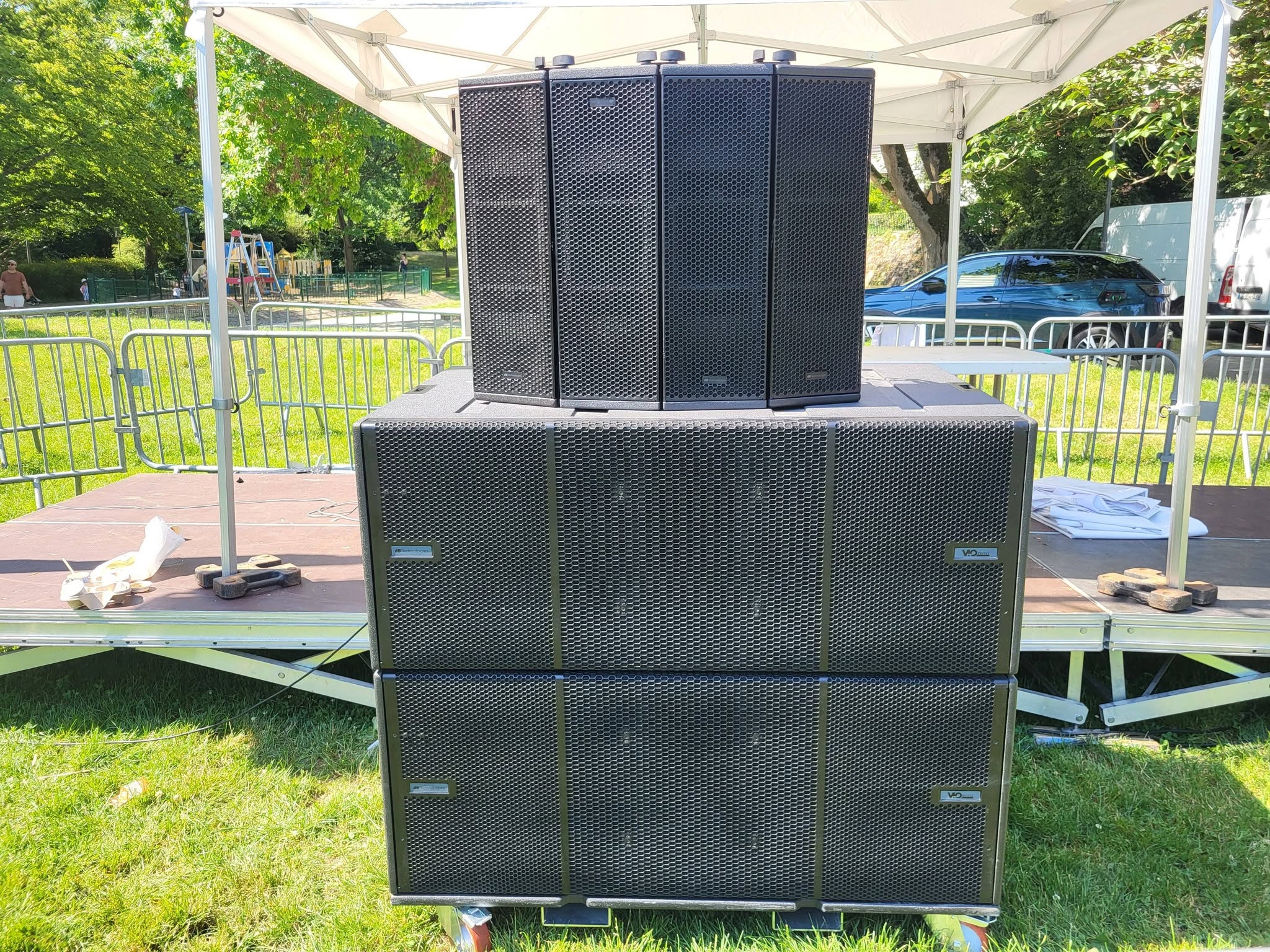 Système de sonorisation installé sur scène, avec plusieurs haut-parleurs en grille noire.