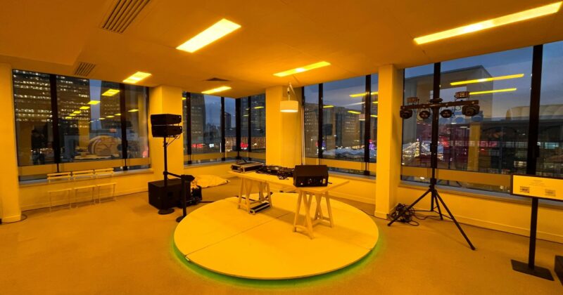 Espace de qualité avec matériel de sono et éclairage installé, vue sur la ville illuminée.