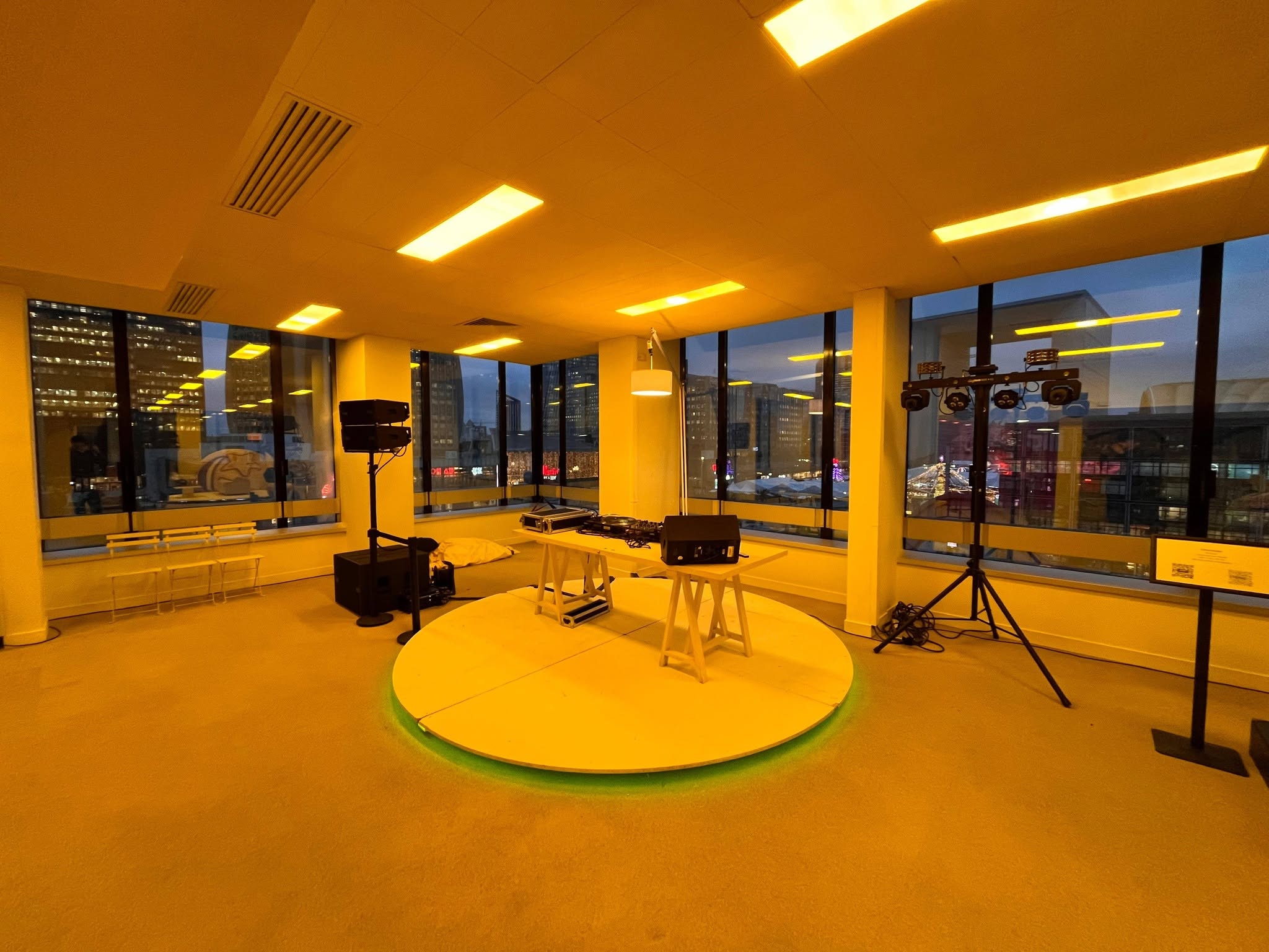 Espace de qualité avec matériel de sono et éclairage installé, vue sur la ville illuminée.