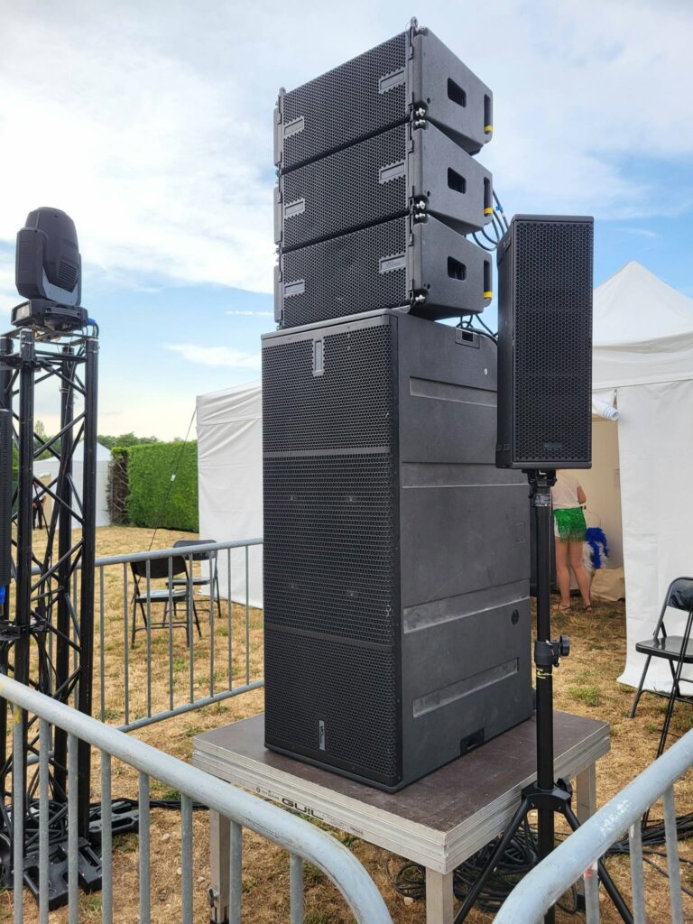 Système de sonorisation professionnel installé sur scène, avec équipements de diffusion sonore.